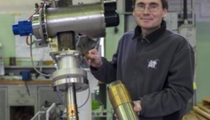 dr Przemysław Adrich i układ formowania wiązki akceleratora IntraLIne (foto: Grzegorz Krzyżewski / NCBJ)