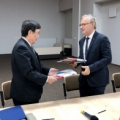   Pre­si­dent Toshio Kodama and NCBJ Direc­tor Gene­ral Krzysz­tof Kurek exchange the docu­ments of the imple­men­ta­tion con­tract (photo: Marek Paw­łow­ski / NCBJ)